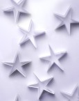 Scattered paper stars on a white background form a lovely delicate backdrop for your Christmas message